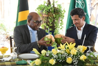 ​Minister of Tourism, Hon. Edmund Bartlett (left) and Minister of Tourism for Saudi Arabia, His Excellency Ahmed Al Khateeb, enjoy coconut water, ahead of the tour of the Global Tourism Resilience and Crisis Management Centre at the University of the West Indies, Mona, on June 23. ​

