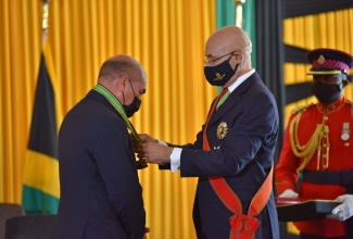 Governor-General , His Excellency the Most Hon. Sir Patrick Allen (right), confers the Order of Distinction, Commander Class, on newly installed Custos of Trelawny,  Hon. Hugh Wayne Gentles,  at the Ocean Coral Spring Hotel, on Thursday (June 17).