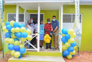 Prime Minister, the Most Hon. Andrew Holness (right) cuts the ribbon to officially hand over a new three-bedroom dwelling to Byron Reid (2nd right) and his common-law wife Zelda Jacobs (3rd right) , in Albert Town, Trelawny  on Friday (July 2). Sharing in the moment (from left) are Member of Parliament for Southern Trelawny, Marisa Dalrymple-Philibert; Custos of Trelawny, Hugh Gentles; and Mayor of Falmouth, Councillor Colin Gager (partially hidden).