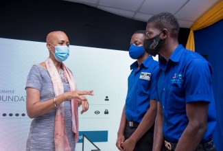 Minister of Education, Youth and Information, Hon. Fayval Williams (left), offers words of encouragement to (from second left), Jevon Josephs; and Roshane Johnson, who are among the second batch of 50 students who will be participating in the Coding in Schools Pilot Programme being undretaken by the MInistry.  Ocassion was a ceremony held on Thursday (July 22) at the Amber/HEART Academy, housed at the Stony Hill HEART Academy in St. Andrew for the electronic handover of $18 million by the NCB Foundation to facilitate the training of this new cohort of students under the programme. 

