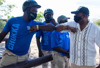 Minister of Tourism, Hon. Edmund Bartlett, greets members of the Chukka Caribbean Adventures team during a recent visit to the entity's Ocho Rios attraction.

