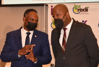 Managing Director, Jamaica Social Investment Fund (JSIF), Omar Sweeney (left), speaks with Chairman of JSIF, Dr. Wayne Henry during the Rural Economic Development Initiative (REDI) II seminar at the AC Hotel by Marriott in St. Andrew on July 29.

