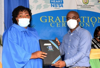 Executive Director, Social Development Commission (SDC), Dr. Dwayne Vernon (right), presents Stacy Ann Gordon with her diploma in Events Planning and Management, during a graduation ceremony held at the SDC’s St. Catherine Office on July 22.