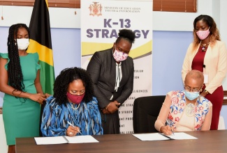 Minister of Education, Youth and Information, Hon. Faval Williams (seated right) and Country Representative for Microsoft, Yamile Bustamante (seated left), sign a Memorandum of Understanding (MoU) for a five-year Digital Skills Programme, at the Ministry’s National Heroes Circle offices in Kingston on Tuesday (July 27). Observing in the background (from left) are: Marketing Manager for Microsoft, Latoya Duffus; Acting Permanent Secretary in the Ministry, Dr. Grace McLean; and Senior Education Officer, Meloney Rhynie.