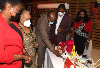 Tourism Minister, Hon. Edmund Bartlett (centre), views products on display during the seventh ‘Christmas in July’ tradeshow at the Jamaica Pegasus Hotel in New Kingston, following the opening ceremony on Thursday (July 22). Others (from left) are: Permanent Secretary in the Tourism Ministry, Jennifer Griffith; Chief Executive Officer, Jamaica Business Development Corporation (JBDC), Valerie Veira; Chairman, Manufacturing Technical Working Group, Tourism Linkages Council, Richard Pandohie; and Director, Tourism Linkages Network, Carolyn McDonald-Riley.