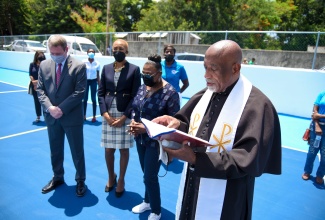 Minister of Culture, Gender, Entertainment and Sport, Hon. Olivia Grange (second right); Minister of Education, Youth and Information and Member of Parliament for St. Andrew Eastern, Hon. Fayval Williams (second left); and Charge d’Affaires at the United States (US) Embassy in Jamaica, Scott Feeken (left), listen as the newly renovated Standpipe Sports Complex, situated at the Church of St. Margaret in St. Andrew, is dedicated by Rector, Fr. Franklyn Jackson. The facility was officially handed over during a recent ceremony.

