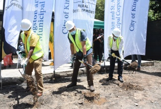 Prime Minister the Most Hon. Andrew Holness (centre), breaks ground on Friday (August 20) for the construction of houses 12 families in Belrock, West Central St. Andrew. Mr. Holness is the Member of Parliament for constituency. Others participating (from left) are: Minister of Local Government and Rural Development, Hon. Desmond McKenzie, and Mayor of Kingston, Senator Delroy Williams.

