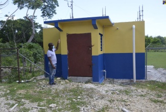 Principal of Little Bay Primary and Infant School in Westmoreland, Keron King, points to the institution’s recently constructed water tank.
