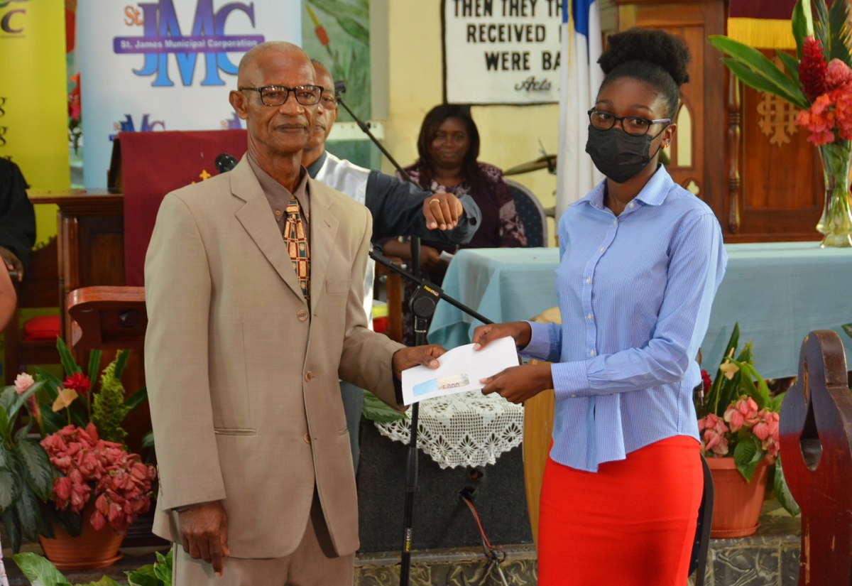 Richard Williams (left) presents a scholarship cheque to 18-year-old Tianna Smith during the Independence church service held at the Maldon Baptist Church in Maroon Town, St. James, on Sunday (August 1). The annual scholarship is in honour of Mr. Williams’ parents, Richard and Mavis Williams.