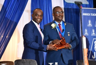 Outgoing President of the Jamaica Teacher’s Association (JTA), Jasford Gabriel (left) , hands over the JTA’s gavel to incoming president of the organisation, Winston Smith. Occasion was the opening ceremony of the 57th JTA annual conference, which was held on Monday (August 16) at the Ocean Coral Spring Hotel in Trelawny. 