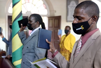 Newly commissioned Justices of the Peace for St. Catherine (from left), Jeffrey McKenzie and Dwight Stewart take the Oath of Office during a virtual commissioning ceremony broadcast from the Phillippo Baptist Church in the parish on Wednesday (August 11).  They were among 207 JPs who were sworn in during the ceremony. The majority of the JPs participated virtually. 

