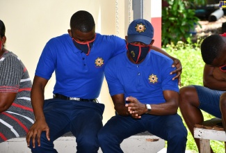 Jamaica Fire Brigade (JFB) firefighter, Nickalous Nelson (left), consoles colleague, Danieto Lawes, during a visit to the Ocho Rios Fire Station in St. Ann by Local Government and Rural Development Minister, Hon. Desmond McKenzie, on Friday (September 17), to offer support to bereaved members in the aftermath of the untimely passing of JFB firefighters, Alex Williams and Stephan Walters, who were involved in a motor vehicle accident on September 13.