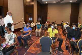 Minister of Tourism, Hon Edmund Bartlett (standing) expresses sincere appreciation to scores of tourism workers during their observation period after taking the vaccine of their choice at the Moon Palace blitz site on Friday, September 3, 2021. He thanked them for playing their part in safeguarding the tourism sector, by taking the lifesaving vaccine.