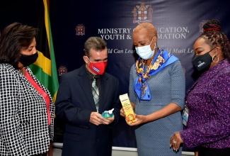 Minister of Education, Youth and Information, Hon. Fayval Williams (second right), looks at  a bottle of cough syrup, which is among pharmaceutical and personal care items contained in care packages, that have been donated for Cuban teachers in Jamaica, by P.A. Benjamin Manufacturing Company Limited. Looking on (from left) are Marketing Manager for Pharmaceuticals and Exports, P.A. Benjamin, Andreen Bennett; Coordinator of the Cuban Educational Brigade in Jamaica, Dr. Reynel Isalgue Isalgué;  and Marketing Manager for Food and Personal Care,  P.A. Benjamin, Lisa Andrade Thompson. The items were handed over at the Ministry’s headquarters in Kingston on Friday (September 24).