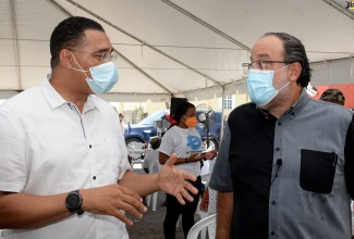 Prime Minister the Most Hon. Andrew Holness (left), in discussion with Opposition Leader, Mark Golding, while visiting a coronavirus (CoVID-19) vaccination site at Caribbean Palms Estate Community Centre in St. Andrew on Friday (September 17).