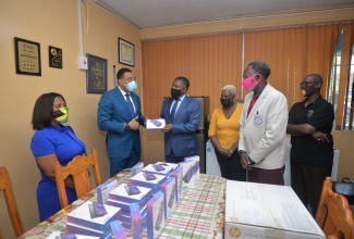 Prime Minister, the Most Hon. Andrew Holness (second left) presents tablet computers to Member of Parliament for East Kingston and Port Royal, Phillip Paulwell (third left) for distribution to students. The presentation was made during a visit to the vaccination site at the Windward Road Primary and Junior High School in East Kingston on Wednesday (September 15). During the visit, Mr. Holness also donated a multifunctional printer to the institution. Looking on (from left) are Councillor for the Norman Gardens Division, Jacqueline Lewis; Councillor, Springfield Division, Lorraine Dobson;  Principal of the school, Noel Pennant; and Minister of Local Government and Rural Development, Hon. Desmond McKenzie.

