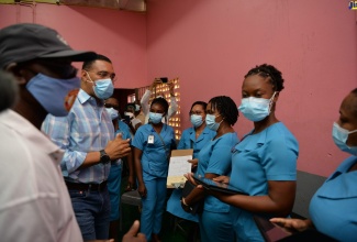 Prime Minister, the Most Hon.  Andrew Holness (second left) gives words of gratitude and encouragement to healthcare workers at the vaccine site at Cross Keys High School during his tour of blitz sites in Manchester on Thursday  (September 16). He was accompanied by Local Government and Rural Development Minister, Hon. Desmond McKenzie.