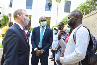 Minister of State in the Ministry of Labour and Social Security, Hon. Zavia Mayne (centre) and Chargé d’Affaires at the U.S. Embassy in Jamaica, Scott Feeken (left), interact with farmworker, Geraldine Weir during a send-off ceremony for agricultural workers at the National Insurance Fund premises in New Kingston. The workers left the island for the United States on Friday (Sept. 3).  Photo: Adrian Walker

