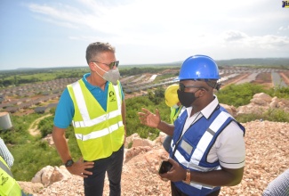 Minister of Housing, Urban Renewal, Environment and Climate Change, Hon. Pearnel Charles Jr. (right), emphasises a point to West Indies Home Contractors Limited  (WIHCON) Chairman, Peter Melhado, during a tour of the SilverSun Estates housing development in St. Catherine, on Friday (October 8).