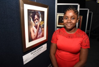 (FILE) Olivia Gordon, student of The Mico University College, stands beside her winning entry. She was the winner of the Photo component of the JIS 2020 Heritage Competition.