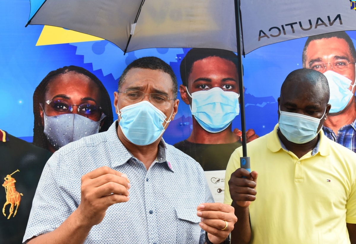 Prime Minister, the Most Hon. Andrew Holness, (left) speaks to journalists during a press briefing at the Redemption Faith Church, a vaccination site in Calderwood St. Ann, on Thursday (October 14). Occasion was a visit  by the PM to the Redemption Faith Church and the Alexandria Community Hospital in the parish. Also taking part in the visit were Minister of State in the Ministry of Labour and Social Security, and Member of Parliament for Southwest St. Ann, Zavia Mayne (right). 