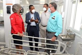 Minister of Science, Energy and Technology, Hon. Daryl Vaz (right), listens to a point being raised by Medical Chief of Staff, University Hospital of the West Indies (UHWI), Dr. Carl Bruce (second left), who led him on a tour of the UHWI coronavirus (COVID-19) Field Hospital in St. Andrew on Friday (October 8). Also participating (from left) are Chief Executive Officer of the Joan Duncan Foundation, Kim Mair; and General Manager, Petrojam Limited, Winston Watson. Petrojam Limited donated two modular tents at a cost of approximately US$24,000 to aid in the establishment of the field hospital. The donation is in alignment with the core elements of Petrojam’s Corporate Social Responsibility Programme, which emphasises the company’s commitment to health and safety.