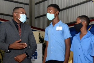 State Minister in the Ministry of Education, Youth and Information, Hon. Robert Morgan (left), speaks with Javaughn Barrett (centre) and Nandre Stewart, at the launch of the Optimist International Caribbean District’s flagship project, ‘Mentorship For At- Risk Youth’, on Wednesday (October 27) at the YMCA in St. Andrew.