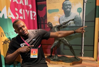 Usain Bolt strikes a pose in front of the maquette of his bronze statue on display in the Jamaica Pavilion at World Expo Dubai 2020 on November 13. Mr. Bolt was taken down memory lane as he viewed images and videos of himself and other Jamaican athletes on display inside the Jamaica Pavilion. 