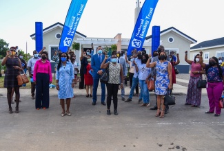 Prime Minister, the Most Hon. Andrew Holness (centre), and National Housing Trust (NHT) Board member, Nesta-Claire Hunter (third left), with new homeowners of the NHT’s Twickenham Glades development in St. Catherine, following the handover ceremony on Wednesday (December 1).

