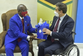 Minister of Local Government and Rural Development, Hon. Desmond McKenzie (left), presents a gift bag to Ambassador of the Republic of Colombia to Jamaica, His Excellency Jairo Raúl Clopatofsky Ghisays, during a courtesy call and bilateral meeting at the Ministry in Kingston on Tuesday (November 30).

