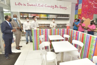 Minister of State in the Ministry of Industry, Investment and Commerce, Hon. Norman Dunn (left); and Member of Parliament for St. Catherine North Western, Hugh Graham (second left), are taken on a tour of the Candy Craze store located at the just opened Progressive Shopping Centre on Barbican Road in St. Andrew. The tour is being led by Directors of Progressive Grocers of Jamaica Limited (pictured from third left), Timothy Lyn; Craig Chin; and Bruce Loshusan. This followed Progressive Grocers of Jamaica Limited’s ribbon cutting ceremony for the grand opening of its Centre on Tuesday (December 14).  This new Shopping Centre is the company’s latest venture and commitment to further contribute to Jamaica’s economy. The company operates 29 supermarkets Island wide and employs 1800 persons across Jamaica. For 22 years, the Progressive Grocers Group has been contributing to improving the social and economic welfare of Jamaicans through retail services, community outreach programmes and various job opportunities. 