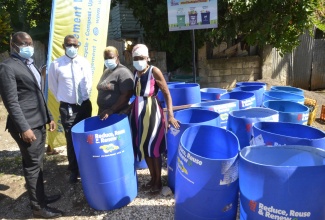  Acting Regional Operations Manager of the NSWMA/Western Parks and Markets (WPM) Waste Management Limited, Dramaine Jones (left), and Councillor for the Flanker Division in St. James, Senator Charles Sinclair (second left), at a ceremony where garbage drums were handed out to residents of Flanker, on December 7.  Residents (from third left) are Shirley Robinson and Catherine Cunningham.