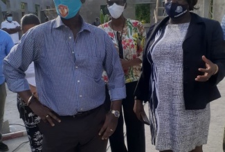 Minister of Local Government and Rural Development , Hon. Desmond McKenzie, (foreground) gets a firsthand view of the progress of work on the new male ward being built at the Westmoreland Infirmary, during a tour of the project site  recently. He is accompanied by Chief Executive Officer at the Westmoreland Municipal Corporation, Marvalyn Pitter (right); and Chief Engineering Officer at the Corporation, Ava Murdock.