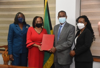 Minister of Finance and the Public Service Dr. the Hon Nigel Clarke (second right), and Jamaica Confederation of Trade Unions (JCTU) President Helene Davis Whyte (second left), display the signed the 2021/22 Heads of Agreement for wage increases for public sector workers represented by JCTU affiliates. Others (from left) are Financial Secretary in the Ministry Darlene Morrison, and State Minister, Hon. Marsha Smith. Photo: Michael Sloley 

