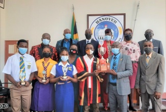 Participants in the Hanover Municipal Corporation’s (HMC) Youth Mayor Competition Robing and Awards Presentation Ceremony which took place during the HMC’s recent monthly meeting. Front row (from left) Youth Councillor, Christopher Campbell, Rusea’s High School; Youth Councillor, Rachel Coach, Hopewell High School; Teacher/Coach, Hopewell High School, Ann-Marie Galloway; Youth Deputy Mayor, Allison Trench, Rusea’s High School; Youth Mayor, Timothy Kent, Rhodes Hall High School; Dean of Discipline/Coach, Rhodes Hall High School, Greogory Hewitt; and Acting Chief Executive Officer, HMC, Romeo Daley. Joining them in the back row (from left) are Councillor Marvell Sewell, Green Island Division; Councillor Fearon DeCarish, Chester Castle Division; Councillor Devon Brown, Hopewell Division; Chair Civic and Community Affairs Committee and Deputy Mayor of Lucea, Councillor Andria Dehaney-Grant; Teacher/Coach, Rusea’s High School, Cyleo Clarke; and HMC Chairman and Lucea Mayor, Councillor Sheridan Samuels.

