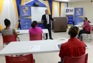 Director, Corruption Prevention, Stakeholder Engagement and Anti-Corruption Strategy at the Integrity Commission, Ryan Evans (centre, standing), addresses participants in the Anti-Corruption and Good Governance Sensitisation Workshop, held recently, at the offices of the Betting, Gaming and Lotteries Commission (BGLC) in Kingston.
