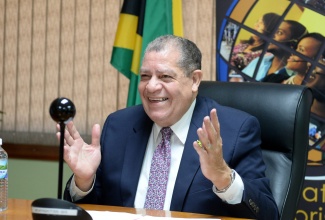 Minister of Industry, Investment and Commerce, Hon. Audley Shaw, engages in a lighthearted moment with participants in the virtual staging of the 19th Annual Shirley Playfair Lecture hosted by the Fair Trading Commission (FTC) on Wednesday (December 8). The Minister was delivering opening remarks from his New Kingston offices.  (Photo: Dave Reid)

