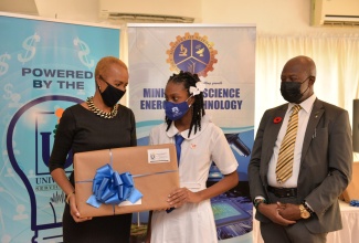 Minister of Education, Youth and Information, Hon. Fayval Williams (left), presents a laptop computer to the top-performing girl for the parish of Westmoreland in the 2021 Primary Exit Profile (PEP), Jaden Drummond. Occasion was the Universal Service Fund (USF) PEP presentation ceremony held at the Altamont Court Hotel in New Kingston, recently. Looking on is Chief Executive Officer, USF, Daniel Dawes.