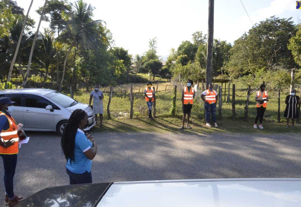 Southern Regional Coordinator for the Office of Disaster Preparedness and Emergency Management (ODPEM), Camille Beckford-Palmer (second left), addresses residents of New River District in St. Elizabeth following a community earthquake and evacuation drill in the area on Tuesday, January 18. Listening keenly is Parish Coordinator for Disaster Preparedness at the St. Elizabeth Municipal Corporation, Ornella Lewis (left).