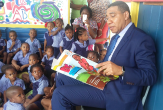 Prime Minister, the Most Hon. Andrew Holness, reading to children at Jamaica House Basic School on Read Across Jamaica Day in 2017. (FILE)