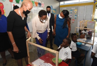 Minister of Education and Youth,  Hon. Fayval Williams (left), and Opposition Spokesperson on Education, Dr. Angela Brown-Burke (second left), interact with a student from Union Gardens Infant School in Kingston, during the virtual launch of the year of Early Childhood Development, which was held today (January 25). Joining them are Commissioner from the Early Childhood Commission (ECC), David Solomon (second right), and ECC Chairwoman, Trisha Williams-Singh. 

