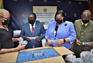 Minister of Education and Youth, Hon. Fayval Williams (left), and (from second left) Regional Director, Region seven, Barrington Richardson; Acting Regional Director for Region Two, Yashieka Blackwood-Grant; and Director for Region five, Ottis Brown, view COVID-19 Home Testing Kits at a  handover ceremony held at the Ministry’s Heroes Circle offices on January 25.