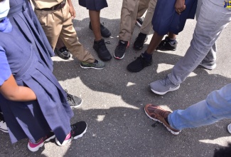 Students from the August Town Primary School in Kingston show sneakers they received from the non-profit organisation, Sole 2 Sole, on Friday, (February 4). 