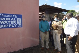 – Minister of Local Government and Rural Development, Hon. Desmond McKenzie (left), is shown a concrete water-harvesting tank at the Springfield Primary and Infant School in St. Elizabeth, by Principal, Winsome Coke (second left), during a recent tour of the school by the Minister. Also participating in the tour are (from third left) Mayor of Black River, Councillor Derrick Sangster; Managing Director of Rural Water Supply Limited (RWSL), Audley Thompson and Deputy Chairman of RWSL , Peter Clarke. 