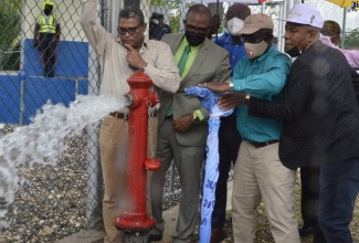 Minister of Local Government and Rural Development, Hon. Desmond McKenzie (fourth left),  turns on the Top Aberdeen , St. Elizabeth, water supply, during an official ceremony held in the community on Thursday (February 3). Sharing the moment (from left) are Deputy Chairman of Rural Water Supply, Peter Clarke; Member of Parliament for St. Elizabeth North Eastern, Delroy Sloley; Acting Regional Manager for the National Water Commission,  Caudel Daley and Councillor of the Siloah Division, Audie Myers. 
