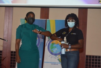 St. James’ Parish Health, Promotion and Education Officer, Julian Grandison Mullings (right), and Human Resource Clerk at Holiday Inn Resort, Shantae Miller, demonstrate an elbow bump as an alternative to a handshake in keeping with COVID-19 safety protocols. This was during Tourism Product Development Company’s first in a series of sensitisation sessions to promote COVID-19 protocols and vaccination, held at the Montego Bay Convention Centre in Rose Hall on Friday (February 25).