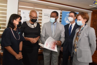 Minister of Finance and the Public Service, Dr. the Hon. Nigel Clarke (centre), speaks with United Nations Children’s Fund (UNICEF) Jamaica Country Representative, Mariko Kagoshima (left), during Wednesday’s (February 23) launch of the Government’s Public Expenditure Review (PER) for Jamaica’s Education Sector. The launch took place at the Finance Ministry in Kingston. Listening (from second left) are Minister of Education and Youth, Hon Fayval Williams, and the World Bank’s Caribbean Country Director, Lilia Buruncuic, and Human Development Programme Leader for the Caribbean, Timothy Johnston. The PER was jointly undertaken by UNICEF and the World Bank.