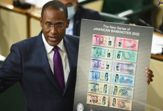 Minister of Finance and the Public Service, Dr. the Hon. Nigel Clarke, points to the new series of Jamaican banknotes as he opened the 2022/23 Budget Debate in the House of Representatives on Tuesday (March 8). In the newly designed banknotes, which will be available late this calendar year, The Most Hon. Michael Manley and The Most Hon. Edward Seaga, will appear together on the $2,000 banknote. In addition, The Right Excellent Paul Bogle and The Right Excellent George William Gordon, will appear together on the upgraded $50 banknote; The Right Excellent Marcus Garvey will appear alone on the upgraded $100 banknote; The Right Excellent Nanny of the Maroons and The Right Excellent Sam Sharpe will appear together on the upgraded $500 note; The Right Excellent Sir Alexander Bustamante and the Right Excellent Norman Manley, who were founding fathers of modern Jamaica, will  appear together on the upgraded $1,000 banknote, and the Most Hon. Donald Sangster and the Most Hon. Hugh Shearer will appear together on the upgraded $5,000 note.