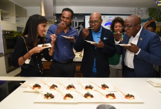 Minister of Tourism, Hon. Edmund Bartlett (centre), samples cuisine infused with coffee during the launch of the Jamaica Blue Mountain Coffee Festival on Tuesday (March 1) at the Jamaica Food and Drink Kitchen, Progressive Plaza, on Barbican Road in St. Andrew. He is joined by (from left), Chairperson, Gastronomy Network, Nicola Madden-Greig; Executive Director, Tourism Enhancement Fund (TEF), Dr. Carey Wallace; President of Jamaica Promotions Corporation (JAMPRO), Dian Edwards (in background); and Minister of Agriculture and Fisheries, Hon. Pearnel Charles Jr.