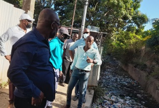 Minister of Local Government and Rural Development, Hon. Desmond McKenzie (third left), listens to Councillor for the Independence City Division, Courtney Edwards (right), while on a recent tour of the Texas Avenue community in Portmore, St. Catherine. In the foreground is Mayor of Portmore, Leon Thomas, and behind Mr. Edwards is Member of Parliament for St. Catherine South East, Robert Miller.

 